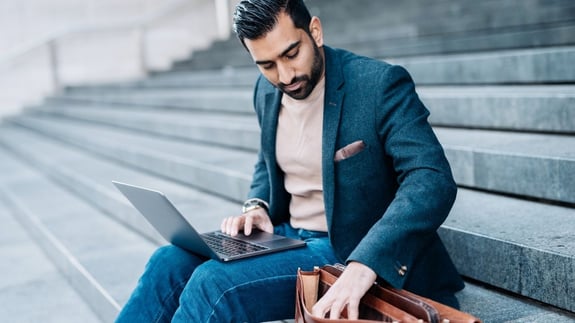Well dressed Indian guy digging in his work bag